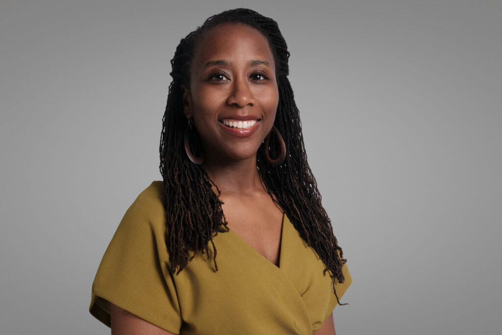 Woman in mustard yellow blouse with locs, warm and approachable headshot in Boston