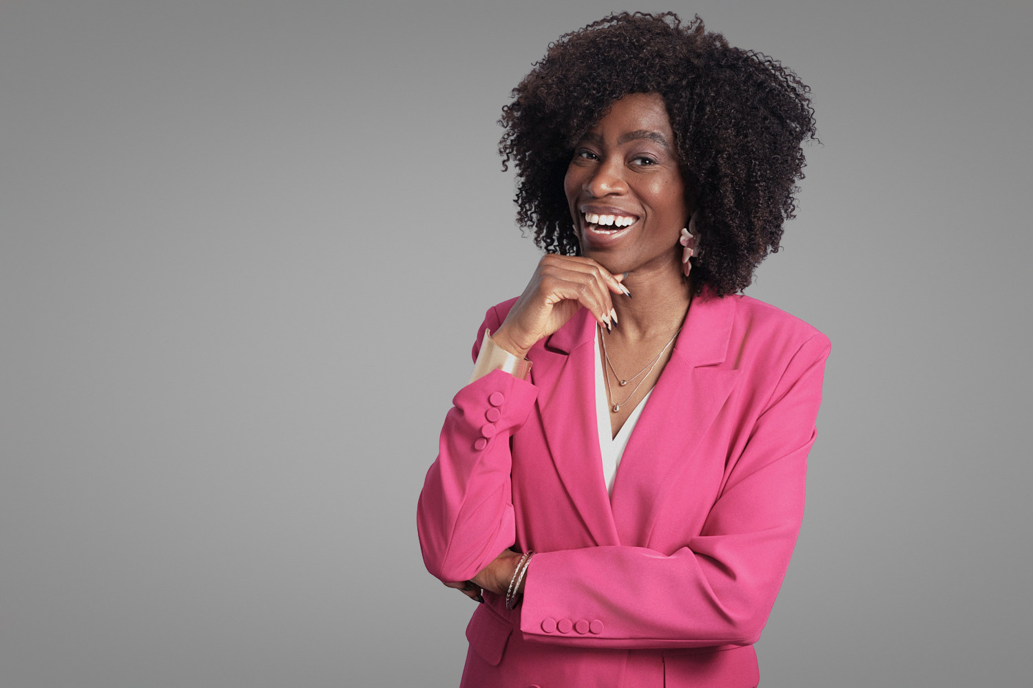Professional woman in pink blazer smiling confidently, taken by Boston headshot photographer